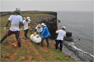 Usingrope, clips and bamboo sticks to hang the garage bags on site.