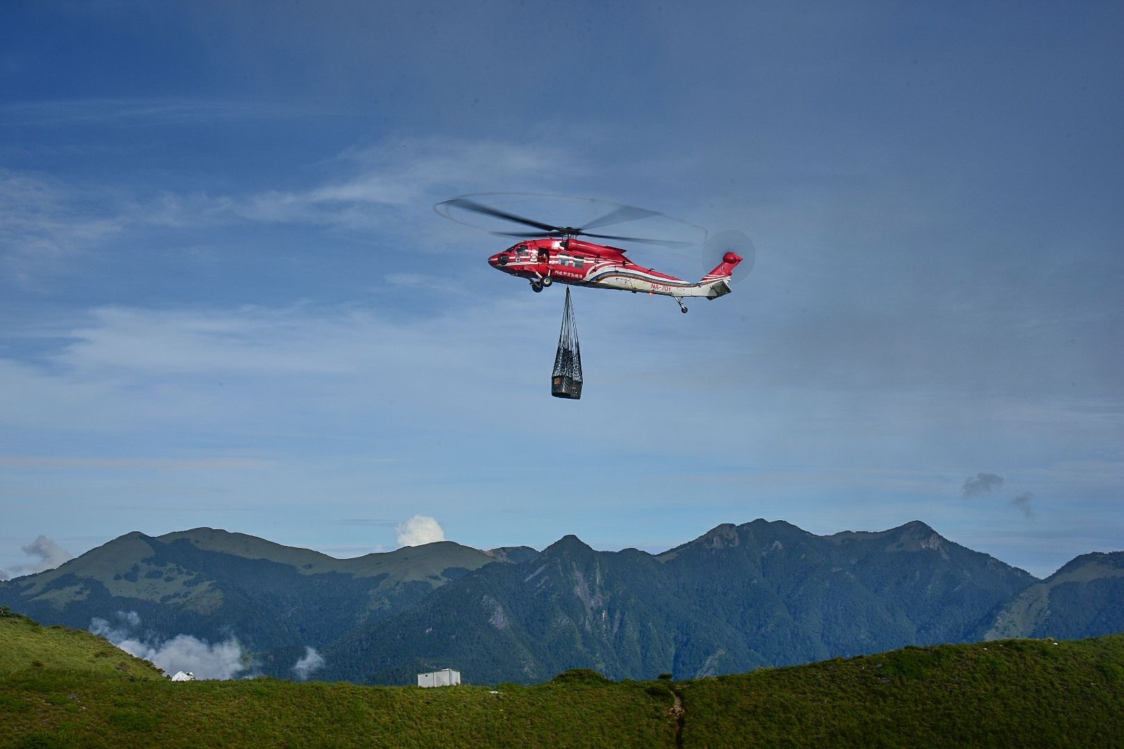 圖1、直升機吊掛建材飛往油婆蘭營地情況
