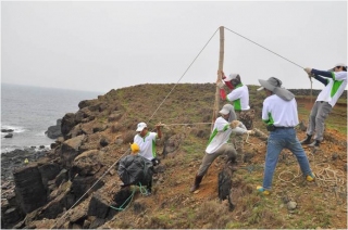 Usingrope, clips and bamboo sticks to hang the garage bags on site.