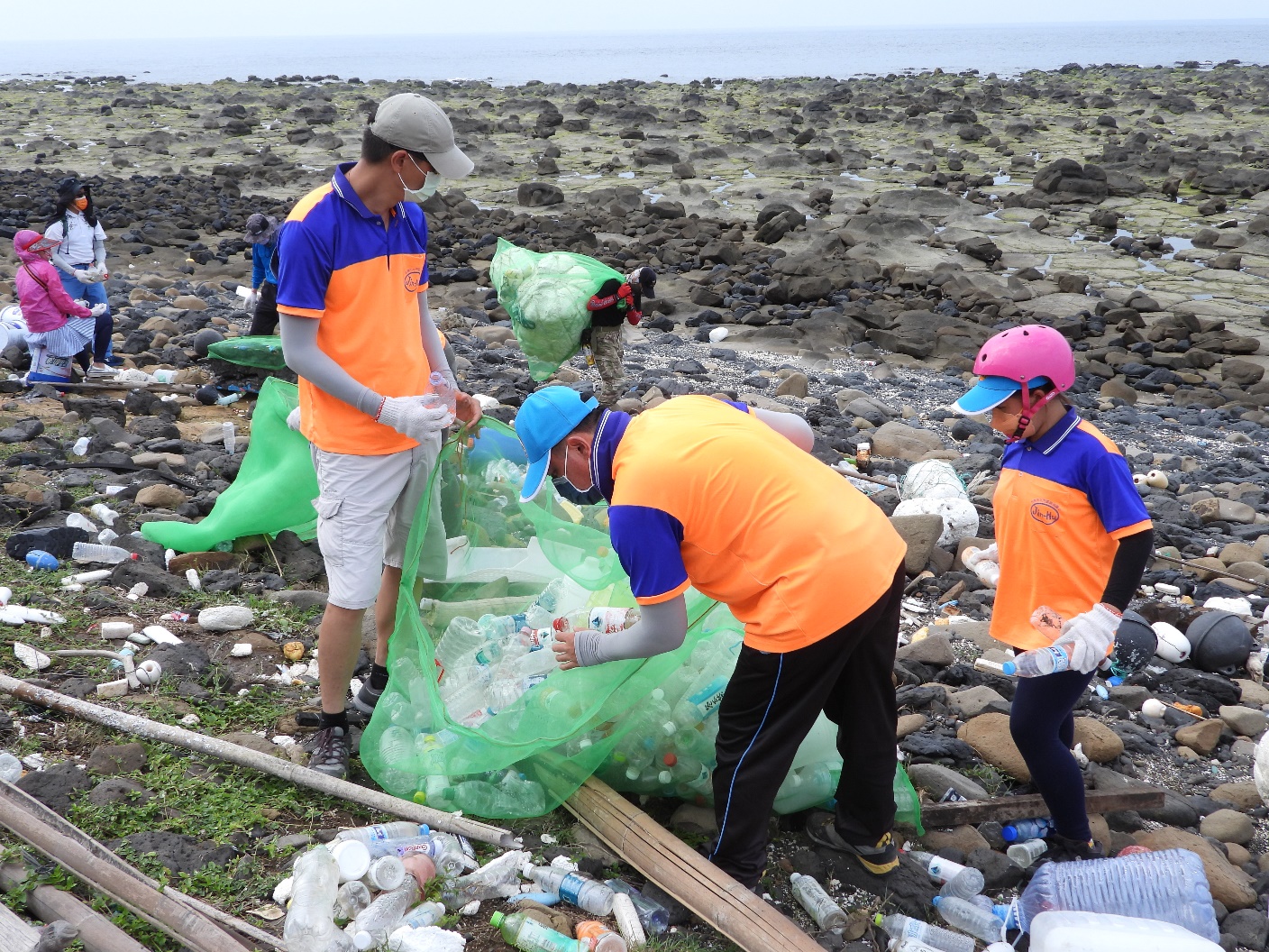 Kumho Elementary School teachers and students work together to clean up the coast below Donggil Lighthouse