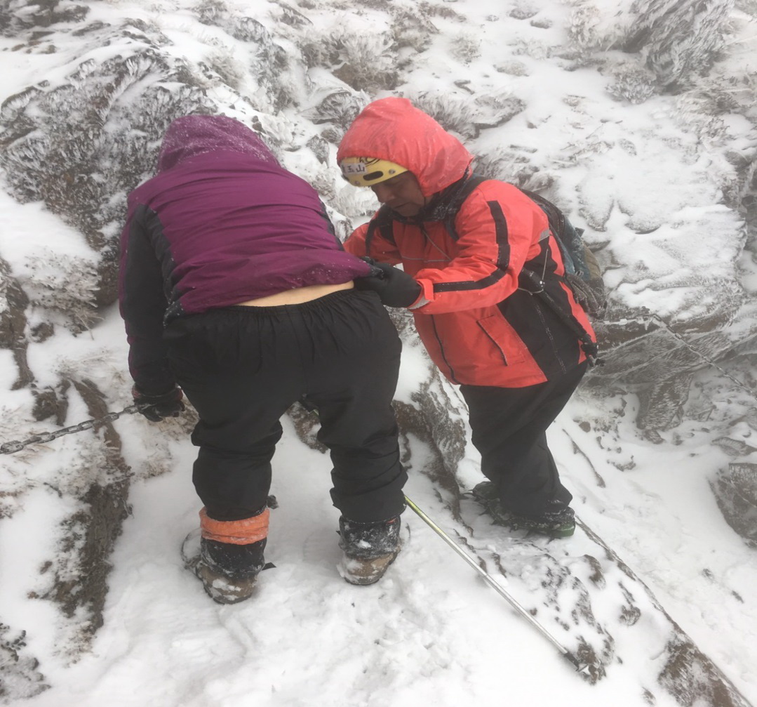 救難人員陪同迷路山友在積雪中一步一步艱難的下山情況